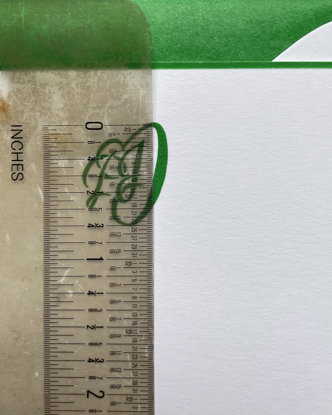 Close-up of engraved monogram with a ruler showing the size of it.